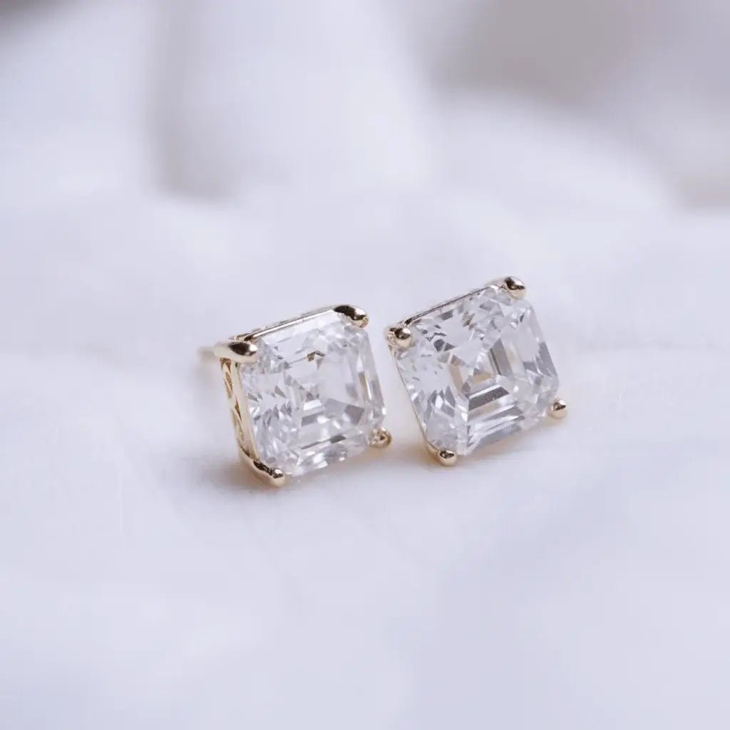 Pair of diamond stud earrings on a light background